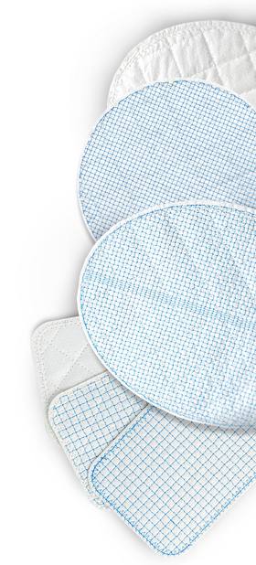 A group of oval and rectangular pads of reinforced tissue matrix, stitched with a fine blue grid, on white
