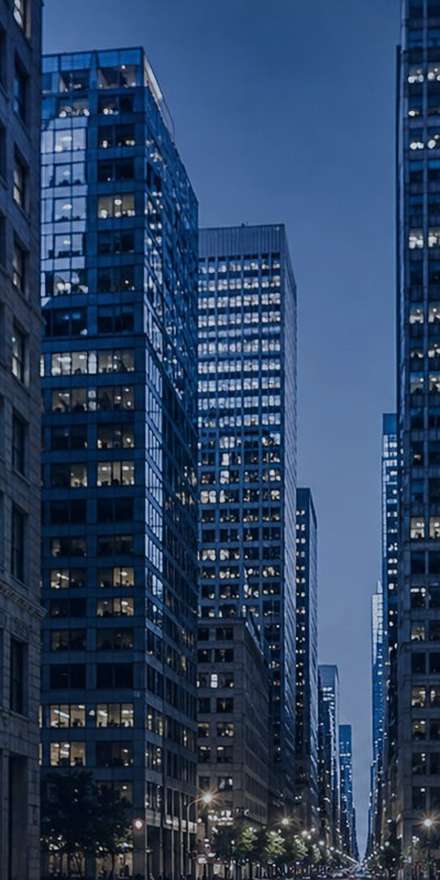 Lit office towers along a Manhattan street at night
