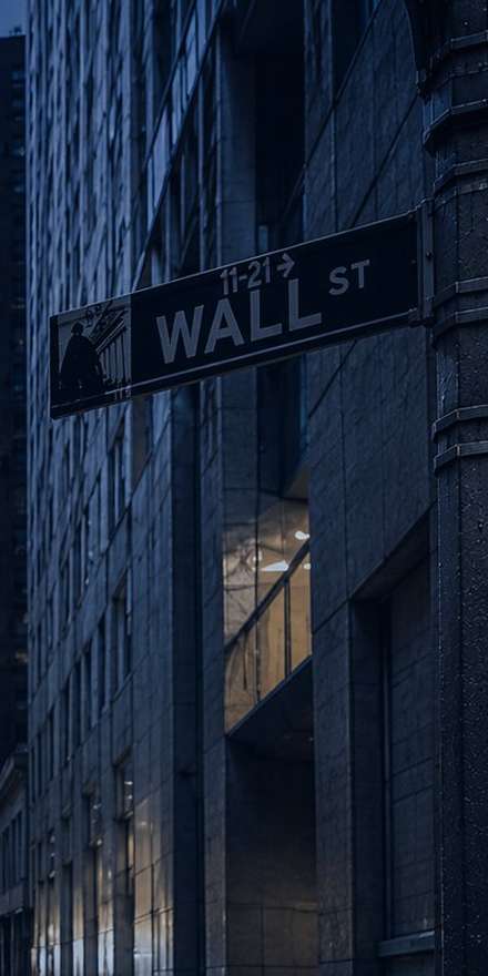 Wall Street street sign on a building at night